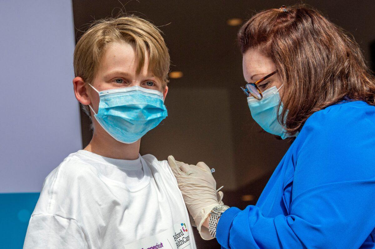 Charles Muro, 13, is inoculated by Nurse Karen Pagliaro at Hartford Healthcare's mass vaccination center at the Connecticut Convention Center in Hartford, Conn., on May 13, 2021. (Joseph Prezioso/AFP via Getty Images)