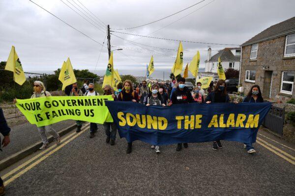Activists from the climate change protest group Extinction Rebellion take part in a protest march in St Ives, Cornwall, England, on June 11, 2021, on the first day of the three-day G7 summit. (Ben Stansall/AFP via Getty Images)