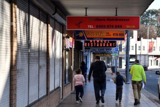 A family walk in front of shuttered shops during a lockdown in the Fairfield in Sydney, Australia, on July 12, 2021 (Saeed Khan/AFP via Getty Images)