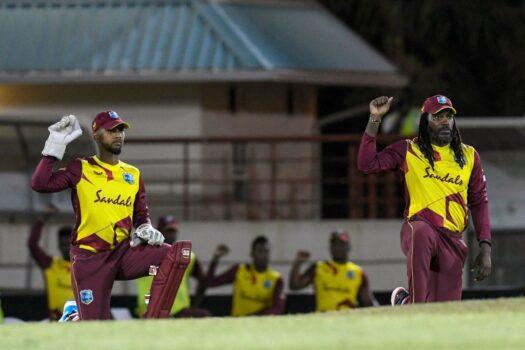 Nicholas Pooran (L) and Chris Gayle (R) of West Indies kneel and raise their fists for Black Lives Matter during the 3rd T20I between Australia and West Indies at Darren Sammy Cricket Ground, Gros-Islet, Saint Lucia, on July 12, 2021. (Randy Brooks/AFP via Getty Images)