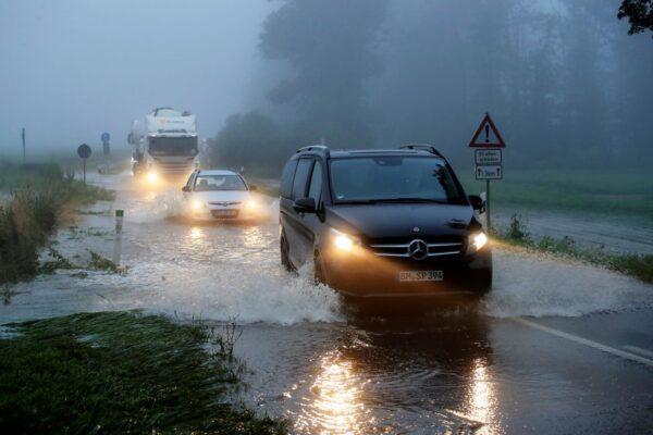 Vehicles travel on a flood affected road after the Erft river swelled following heavy rainfalls in Erftstadt, near Cologne, Germany, July 15, 2021. (Wolfgang Rattay/Reuters)
