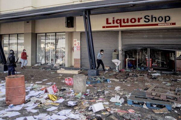 A South Africa Police Service officer tries to disperse rioters looting a liquor shop at the Jabulani Mall in the Soweto district of Johannesburg on July 12, 2021. (Luca Sola/AFP via Getty Images)