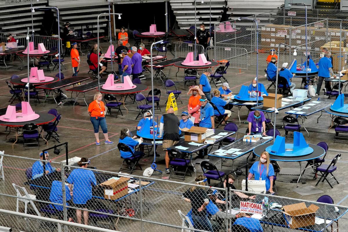 Maricopa County ballots cast in the 2020 general election are examined and recounted by contractors working for Florida-based company, Cyber Ninjas at Veterans Memorial Coliseum in Phoenix, Arizona, on May 6, 2021. (Matt York/AP Photo)