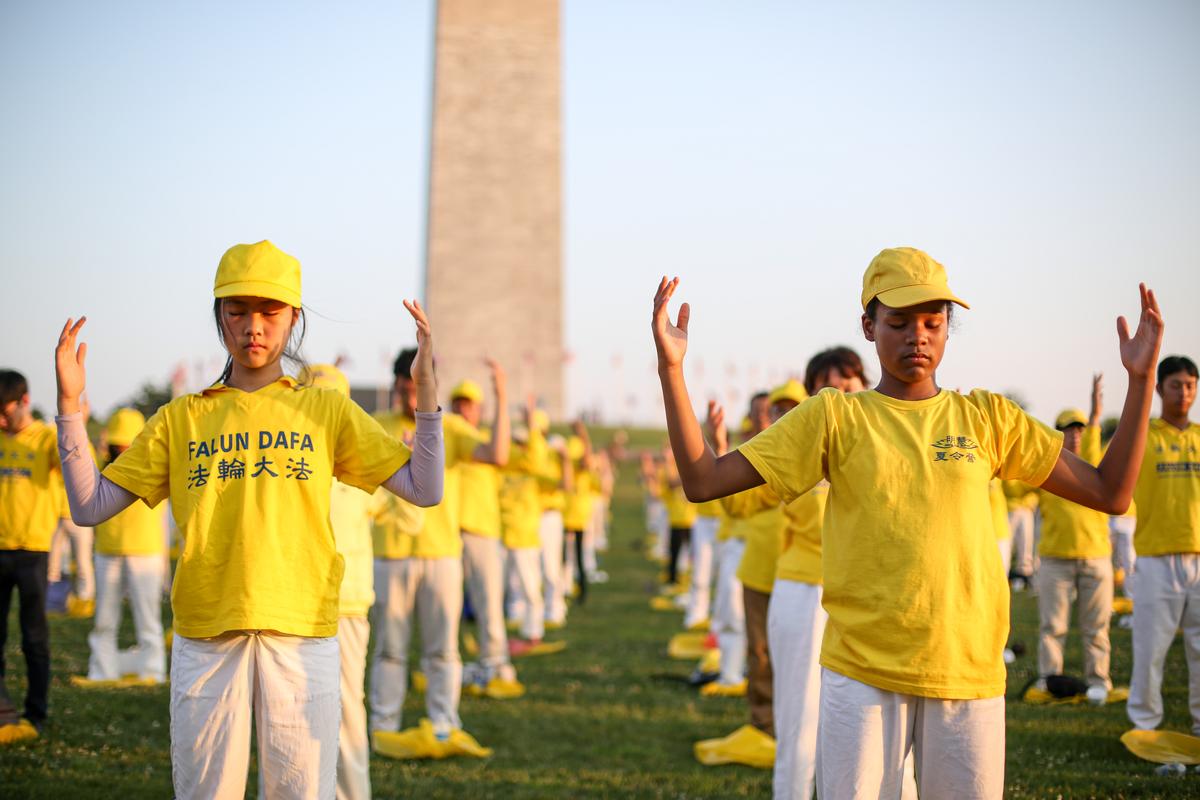 Falun Gong practitioners do the second exercise at an event marking the 22nd anniversary of the start of the Chinese regime’s persecution of Falun Gong, in Washington on July 16, 2021. (Samira Bouaou/The Epoch Times)