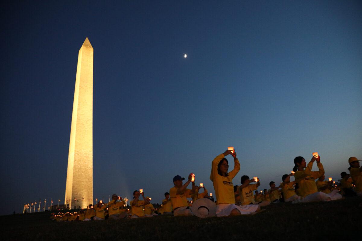 Falun Gong practitioners take part in a candlelight vigil remembering victims of persecution in China at the Washington Monument on July 16, 2021. (Samira Bouaou/The Epoch Times).