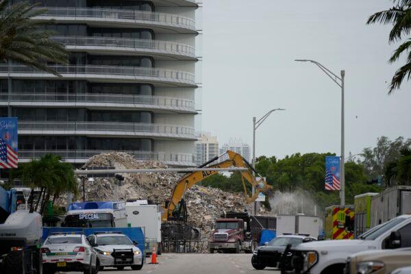 An excavator removes the rubble of the demolished section of the Champlain Towers South building, as recovery work continues at the site of the partially collapsed condo building, in Surfside, Fla., on July 12, 2021. (Rebecca Blackwell/AP Photo)