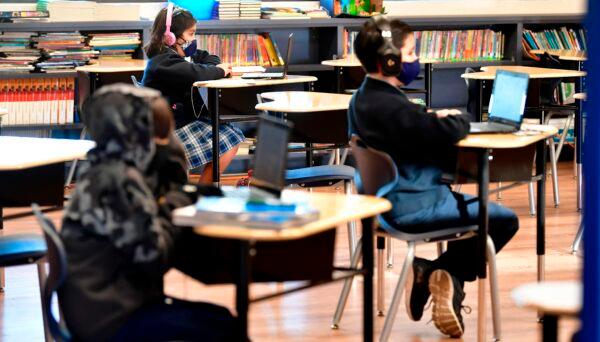 Students sit with their laptop computers at St. Joseph Catholic School in La Puente, Calif., on Nov. 16, 2020. (Frederic J. Brown/AFP via Getty Images)
