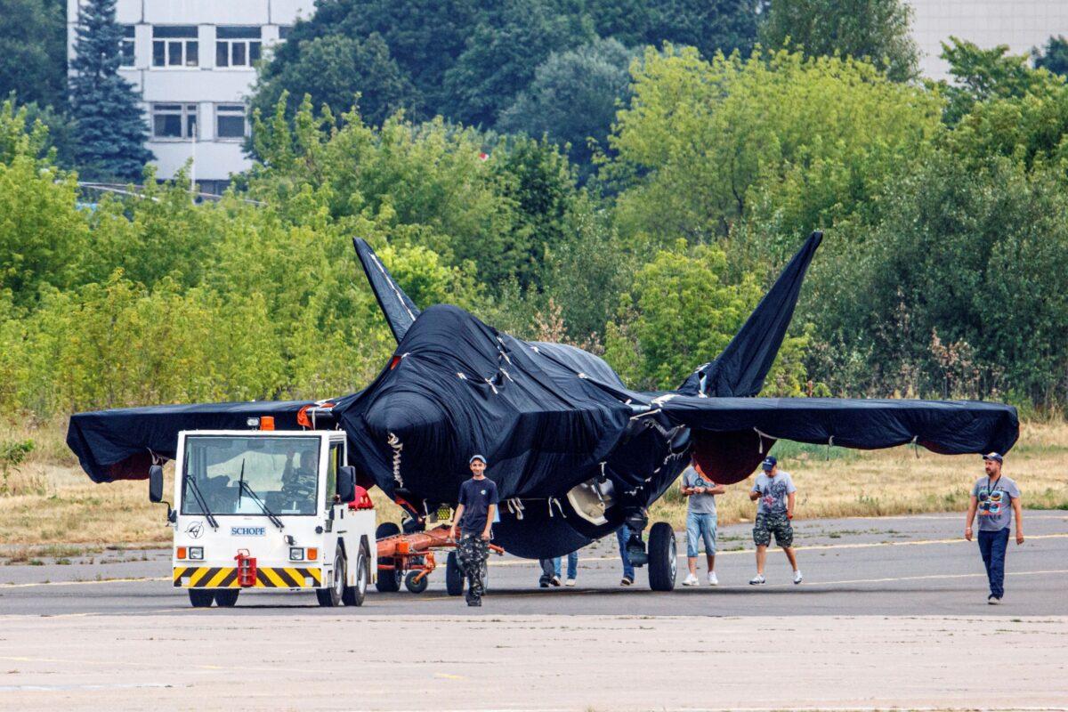Hidden under a tarpaulin, a prospective Russian fighter jet is seen being towed to a parking spot before its presentation at the Moscow international air show in Zhukovsky outside Moscow, Russia, on July 15, 2021. (Ivan Novikov-Dvinsky/AP Photo)