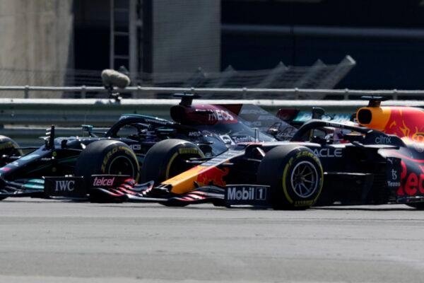 Mercedes driver Lewis Hamilton of Britain, left, and Red Bull driver Max Verstappen of the Netherlands take a curve side-by-side at the start of the British Formula One Grand Prix, at the Silverstone circuit, in Silverstone, England, on July 18, 2021. (Jon Super/AP Photo)