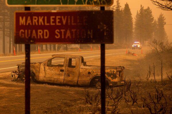 A scorched car rests on a roadside as the Tamarack Fire burns in the Markleeville community of Alpine County, Calif., on July 17, 2021. (Noah Berger/AP Photo)