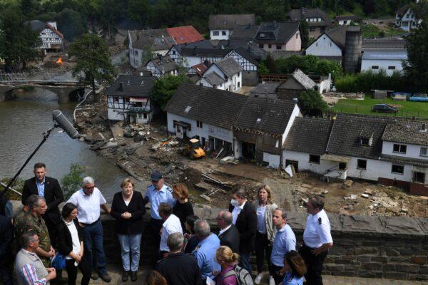 German Chancellor Angela Merkel and Rhineland-Palatinate State Premier Malu Dreyer speak to people as they stand on a bridge during their visit in the flood-ravaged areas, in Schuld near Bad Neuenahr-Ahrweiler, Rhineland-Palatinate state, Germany on July 18, 2021. (Christof Stache/Pool via Reuters)