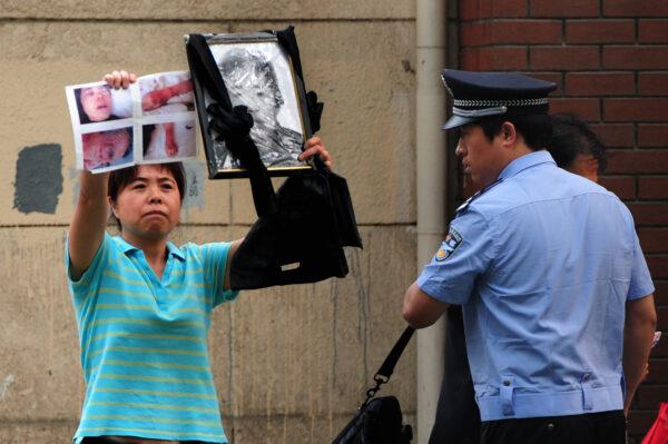 A police officer is trying to detain a petitioner, who is protesting about medical issues, outside the Chaoyang Hospital in Beijing, China on May 10, 2012. (Mark Ralston/AFP/GettyImages)