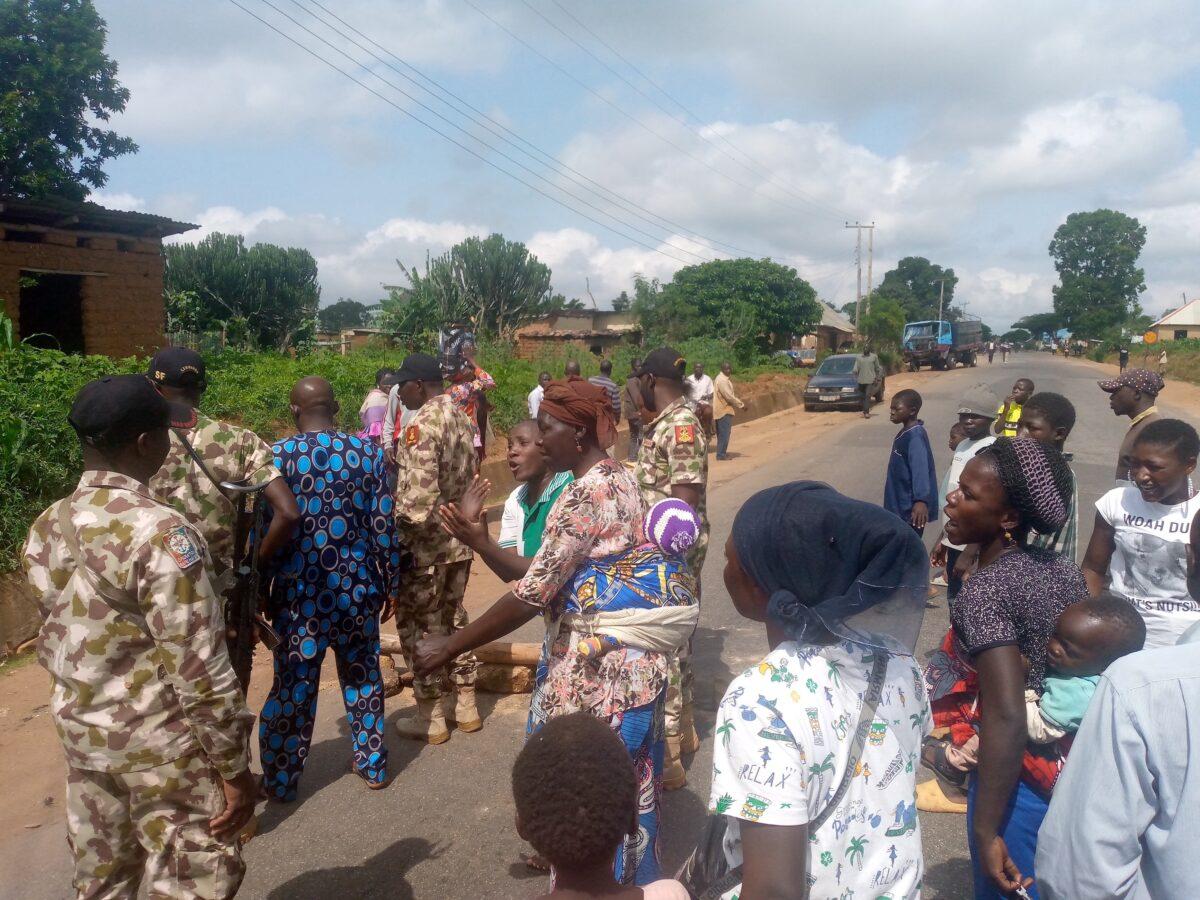 Women and children demand the withdrawal of the military after the alleged shooting of two civilians, in a conflict Zone south of Jos, Nigeria, on July 14, 2021. Protestors tell military officials who visit protest grounds that they no longer trust the army to protect them. (Masara Kim/The Epoch Times)