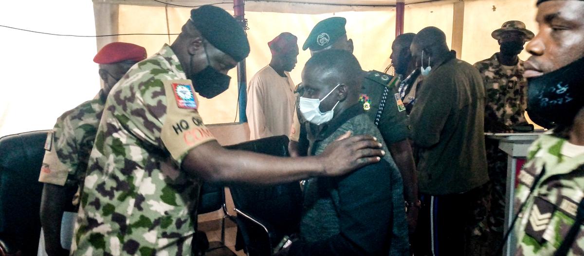 Gen. Ibrahim Ali publicly apologizes to a victim of a military shooting, Gyang Dachollom, during a news briefing at Special Task Force headquarters in the conflict zone south of Jos, Nigeria, on July 15, 2021. Masara Kim