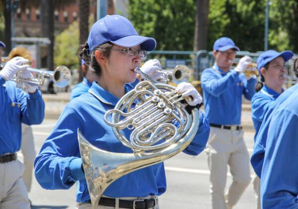 Jenny Zhang plays the French horn in the Tianguo Marching Band in San Francisco on July 17, 2021. (Cynthia Cai/The Epoch Times)