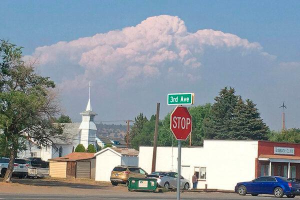 In this photo provided by the Bootleg Fire Incident Command, smoke from the Bootleg Fire rises behind the town of Bonanza, Ore., on July 15, 2021. (Bootleg Fire Incident Command via AP)