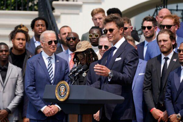 President Joe Biden, surrounded by members of the Tampa Bay Buccaneers, listens as Tampa Bay Buccaneers quarterback Tom Brady speaks during a ceremony on the South Lawn of the White House, where Biden honored the Super Bowl Champion Tampa Bay Buccaneers for their Super Bowl LV victory, in Washington, on July 20, 2021. (Manuel Balce Ceneta/AP Photo)