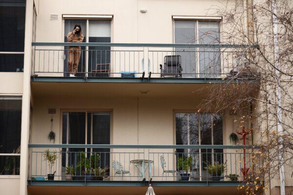 A person speaks on their phone on a balcony of an apartment in Melbourne, Australia, on June 15, 2021. (AAP Image/Daniel Pockett)