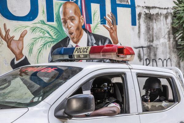 A police convoy drives past a wall painted with the president's image down the alley of the entrance to the residence of the president in Port-au-Prince, Haiti, on July 15, 2021. (Valerie Baeriswyl/AFP via Getty Images)