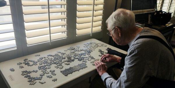 Arthur Moss assembling a 200-piece puzzle reproduction of a photo featuring the USS Bon Homme Richard at his home in Apple Valley, Calif. on May 23, 2021. (Photo courtesy of Arthur Moss)