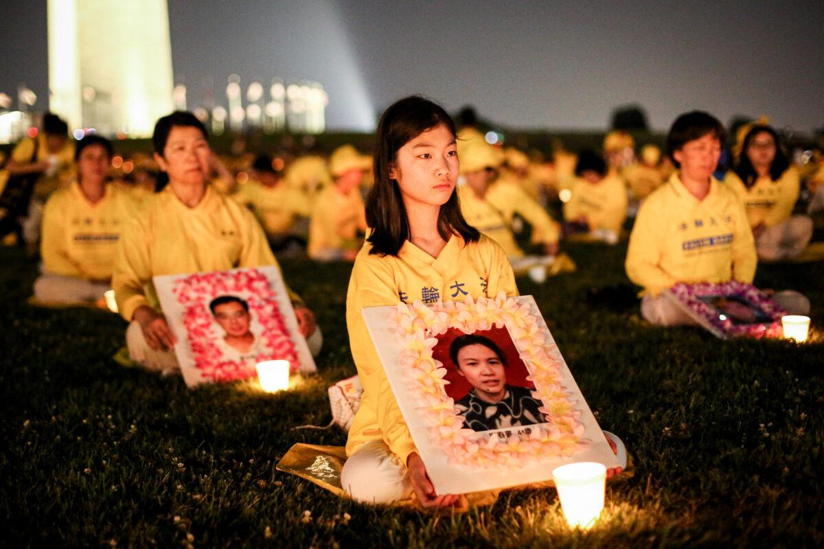 Falun Gong practitioners take part in a candlelight vigil remembering victims of the 22-year-long persecution in China at the Washington Monument, in Washington, on July 16, 2021. (Samira Bouaou/The Epoch Times)