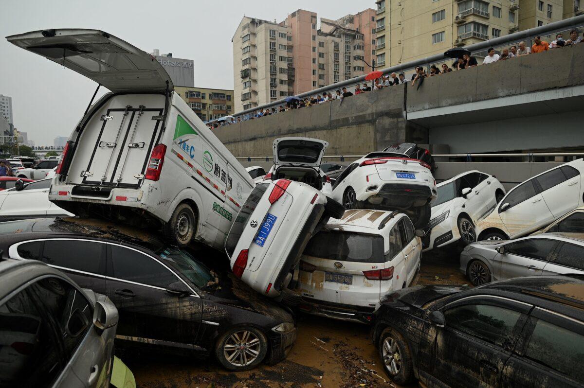 People look at cars sitting in floodwaters following heavy rains, in Zhengzhou, China, on July 22, 2021. (Noel Celis/AFP via Getty Images)