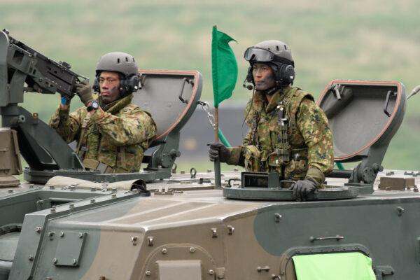 Japan's Ground Self-Defense Forces (JGSDF) soldiers ride a Type 99 155 mm self-propelled howitzer during a live fire exercise at JGSDF's training grounds in the East Fuji Maneuver Area in Gotemba, Shizuoka, Japan on May 22, 2021. (Akio Kon - Pool/Getty Images)