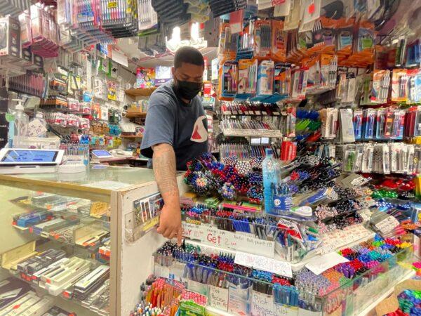 Staff member points to supplies on display at Stationery and Toy World in New York City on July 21, 2021. (Joyce Philippe/Reuters)