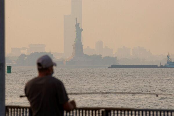 The Statue of Liberty is seen through a cover of wildfire smoke in New York Harbor as seen from Brooklyn, N.Y., on July 21, 2021. (Brendan McDermid/Reuters)
