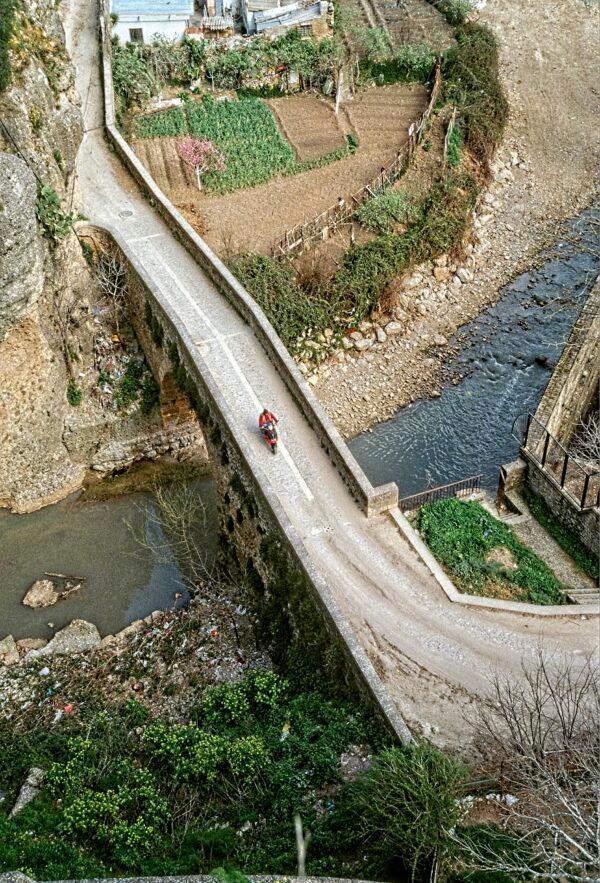 A motorcycle crosses Ronda’s 14th-century Moorish bridge. (Copyright by Fred J Eckert)