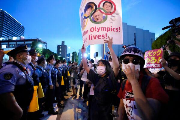Anti-Olympics protesters (R) stage a rally in front of lines of policemen near National Stadium in Tokyo, Japan, on July 23, 2021. (Ryosuke Uematsu/Kyodo News via AP)