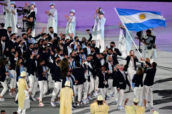 Cecilia Carranza Saroli and Santiago Raul Lange of Argentina (R) carry their country's flag during the opening ceremony in the Olympic Stadium at the 2020 Summer Olympics in Tokyo, Japan, on July 23, 2021. (Patrick Semansky/AP Photo)