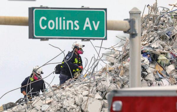 Search and rescue team members climb the debris field of the 12-story oceanfront condo, Champlain Towers South along Collins Avenue in Surfside, Fla., on July 7, 2021. (Al Diaz/Miami Herald via AP)