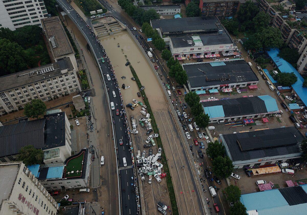 An aerial view shows cars sitting in floodwaters at the entrance of Jingguang Expressway tunnel after heavy rains hit the city of Zhengzhou in China's central Henan Province on July 22, 2021. (Noel Celis/AFP)