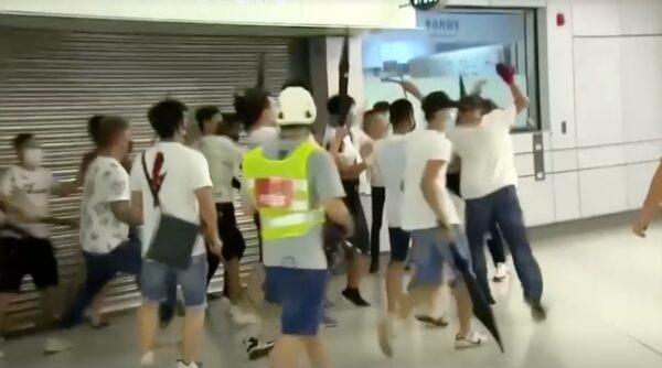 Men in white T-shirts attack anti-extradition bill demonstrators and reporters at a train station in Hong Kong, on July 21, 2019. (TVB via Reuters/Screenshot via NTD)