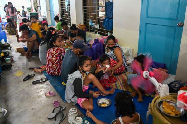 Residents have a meal after being evacuated at a school amid heavy rains that caused flooding in some areas in Marikina city, Metro Manila, Philippines, on July 24, 2021. (Lisa Marie David/Reuters)