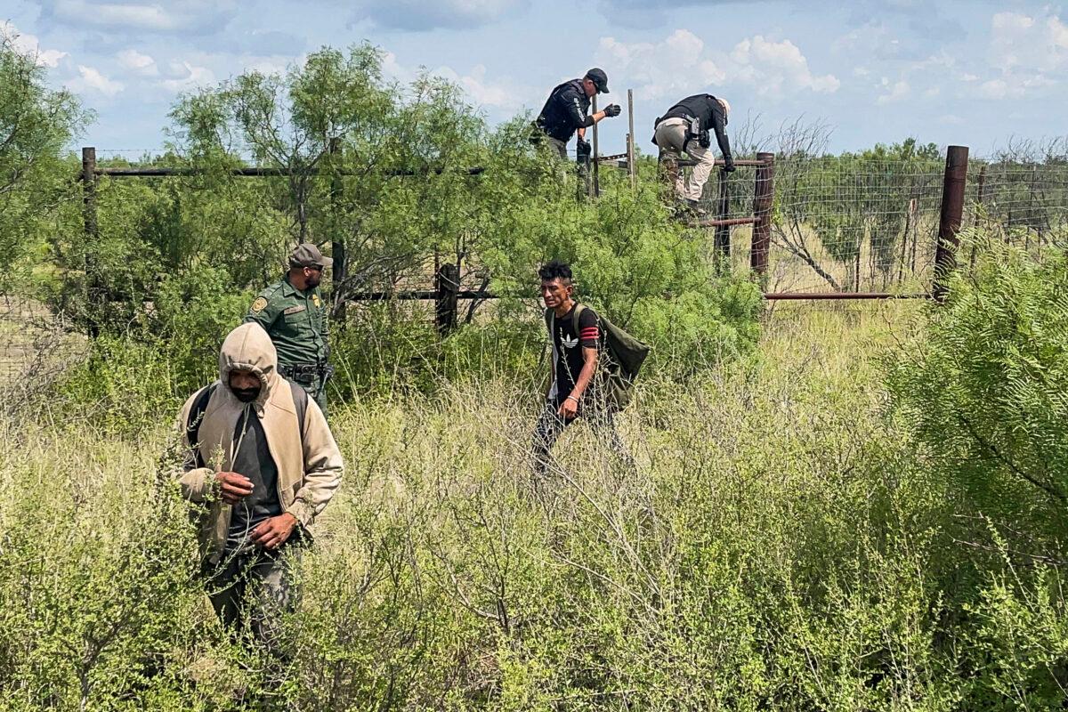 Border Patrol agents and Florida State Troopers (on fence) catch six Hondurans, including an 8-year-old boy, in Kinney County, Texas, on July 21, 2021. (Charlotte Cuthbertson/The Epoch Times)