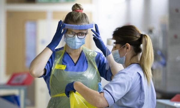 Nurses changing their PPE on Ward 5, a COVID Red Ward, at the Royal Alexandra Hospital in Paisley, Scotland, on Jan.27, 2021. (Jane Barlow/PA)