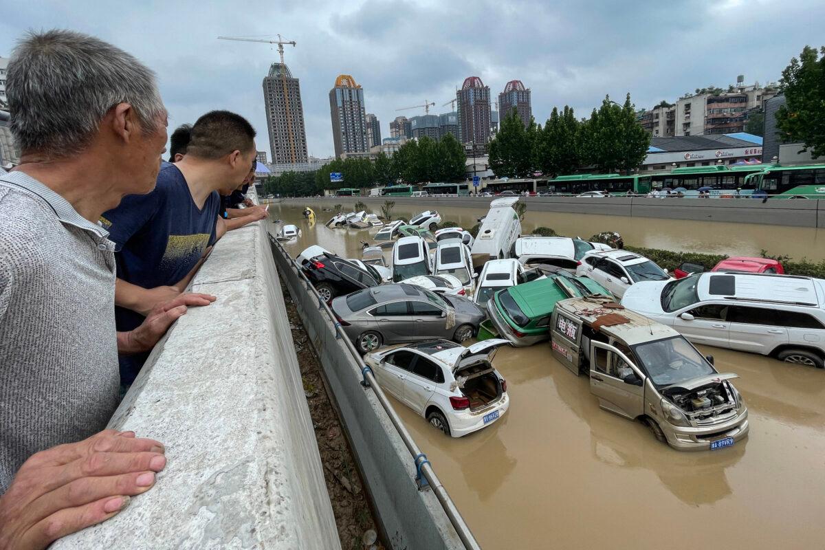 People look out at cars sitting in floodwaters after heavy rains hit the city of Zhengzhou in China's central Henan Province on July 21, 2021. (STR/AFP via Getty Images)