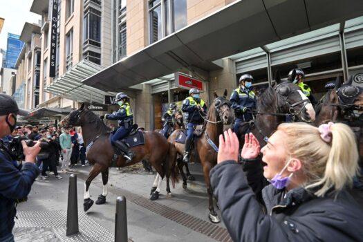 Police officers on horseback disperse protesters during a rally in Sydney, Australia, on, July 24, 2021, as thousands of people gathered to demonstrate against the city's month-long stay-at-home orders. (Steven Saphore/AFP via Getty Images)