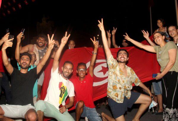 Demonstrators celebrate with a Tunisian national flag during a rally after the president suspended the legislature and fired the prime minister in Tunis, Tunisia, on July 25, 2021. (Hedi Azouz/AP Photo)