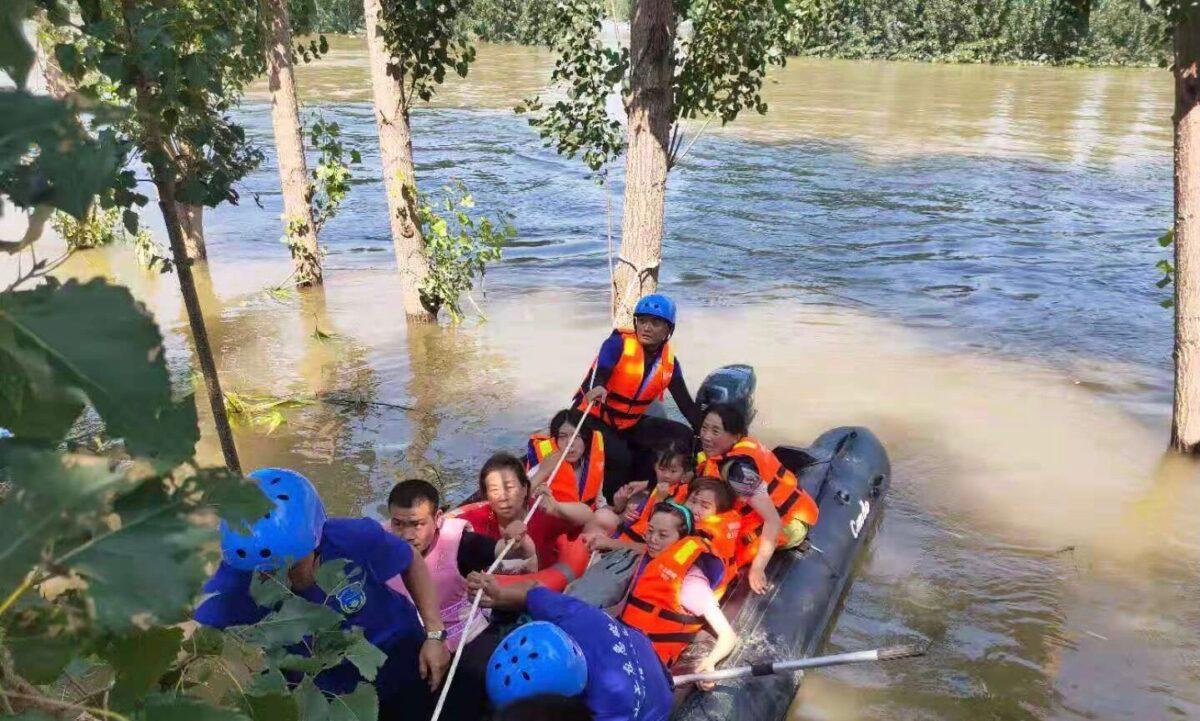 A volunteer team helps rescue flood-impacted villagers in Xinxiang City, Henan Province, China, on July 25, 2021. (Provided to The Epoch Times)