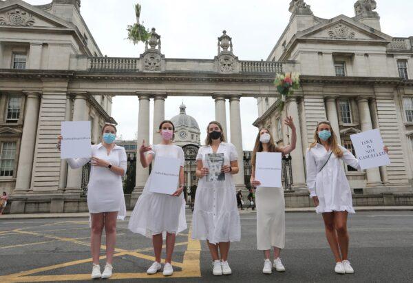 Orla Hogan, Ali O'Mara, Brana Culle, Anna Killeen, and Orla O'Huadaigh hold up signs at a protest march to Government Buildings in a bid to allow up to 100 guests to attend weddings this year in Dublin, Ireland, on July 27, 2021. (Lorraine O'Sullivan/Reuters)