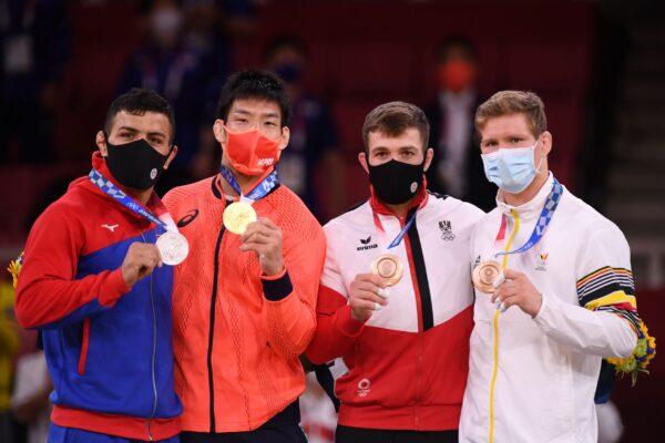 Gold medallist Takanori Nagase of Japan (second left), silver medallist Saeid Mollaei of Mongolia (left), bronze medallist Shamil Borchashvili of Austria (second right), and bronze medallist Matthias Casse of Belgium (right), pose with their medals at the 2020 Summer Olympics in Tokyo, Japan, on July 27, 2021. (Annegret Hilse/Reuters)
