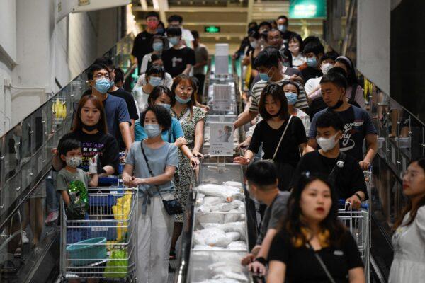 Customers use escalators in a shopping center in Beijing,  on July 25, 2021. (Wang Zhao/AFP via Getty Images)