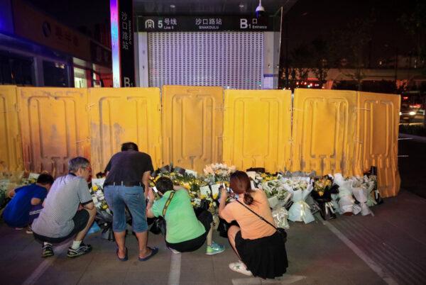 People are placing flowers in front of a subway station as they mourn victims killed in flooding in Zhengzhou, central China's Henan Province, on July 26, 2021. (STR/AFP via Getty Images)