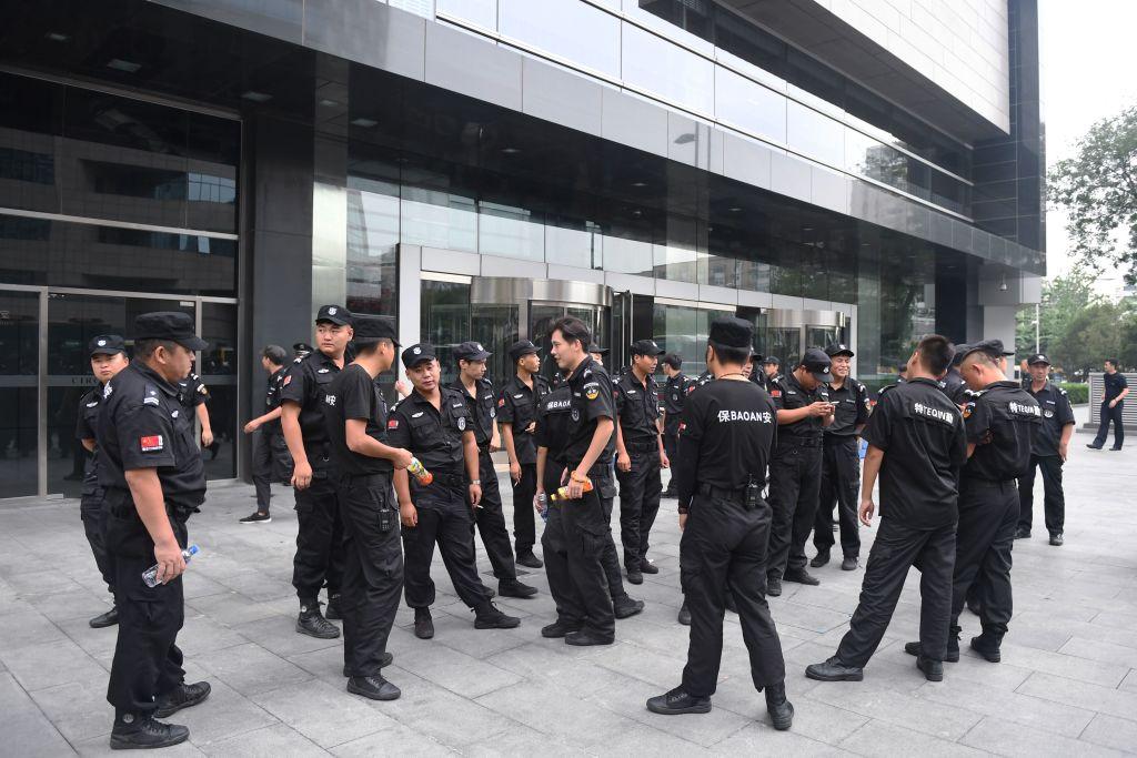 Security personnel stand in front of China's Banking Regulatory Commission in Beijing on Aug. 6, 2018, after Chinese police aggressively quashed a planned protest against losses sustained by peer-to-peer lending platforms. (Greg Baker/AFP via Getty Images)