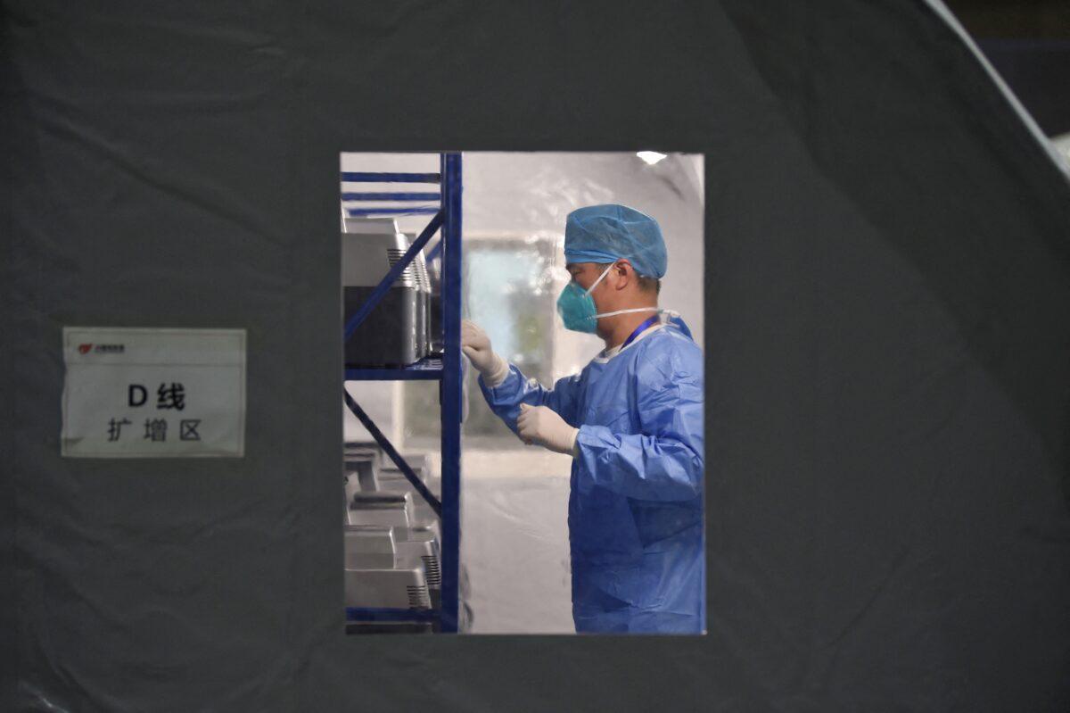 A staff member is working at a temporary laboratory used for COVID-19 testing at an exhibition center in Nanjing, eastern China's Jiangsu Province on July 28, 2021. (STR/AFP via Getty Images)
