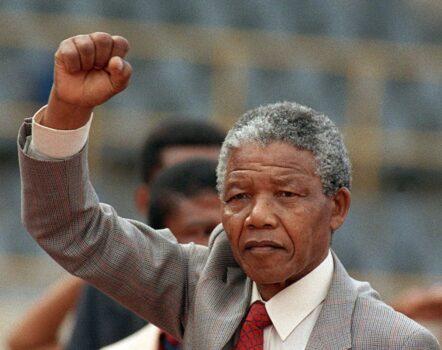 Anti-apartheid leader and African National Congress (ANC) member Nelson Mandela raises a clenched fist, arriving to address a mass rally, a few days after his release from jail arriving in Bloemfontein, South Africa on Feb. 25, 1990, (Trevor Samson/AFP via Getty Images)