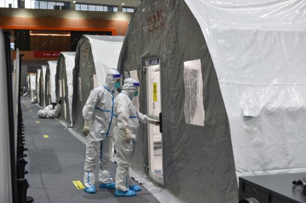 Staff members checking a unit at a temporary "Fire Eye" laboratory used for COVID-19 testing at an exhibition center in Nanjing in China's eastern Jiangsu Province on July 28, 2021. (STR/AFP via Getty Images)